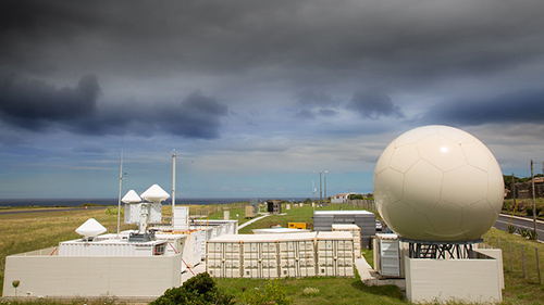 With the ocean in the distance, dark clouds hang over ARM's Eastern North Atlantic atmospheric observatory.