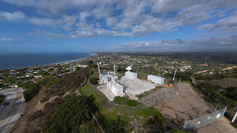 In La Jolla, California, clouds streak across the sky while ARM radars, guest instruments, and containers on Mount Soledad overlook the nearby area, including the Pacific Ocean, during the EPCAPE campaign.
