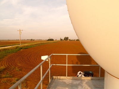 A summer storm begins to gather at the Southern Great Plains atmospheric observatory, with the edge of a radar in the foreground.