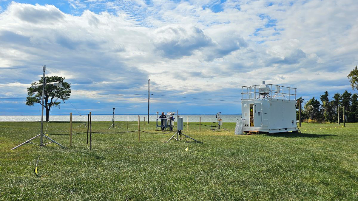 ARM instruments are sited on a field overlooking a bay on a cloudy day.