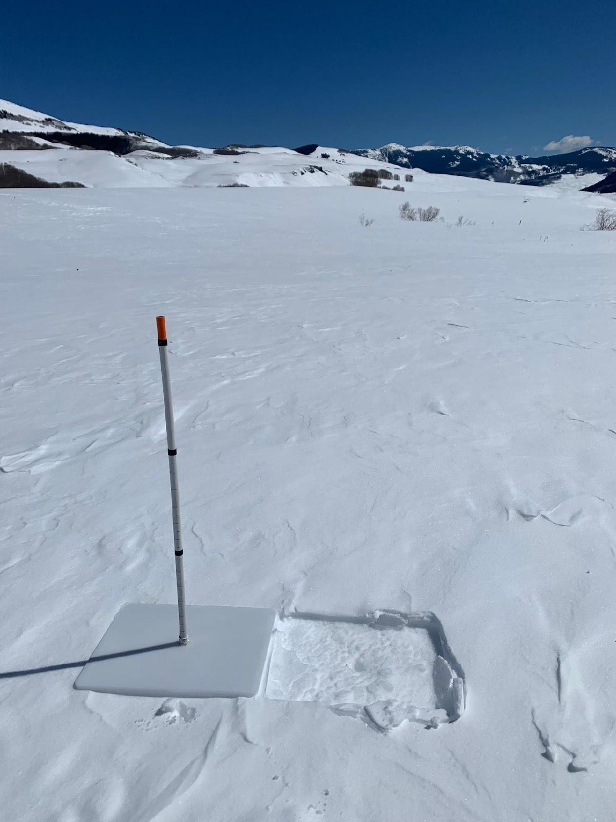 An imprint is left in the snow from a storm board that measures snow accumulation. 