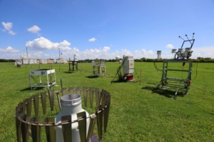 An instrument field on green grass with a clear blue sky with white clouds