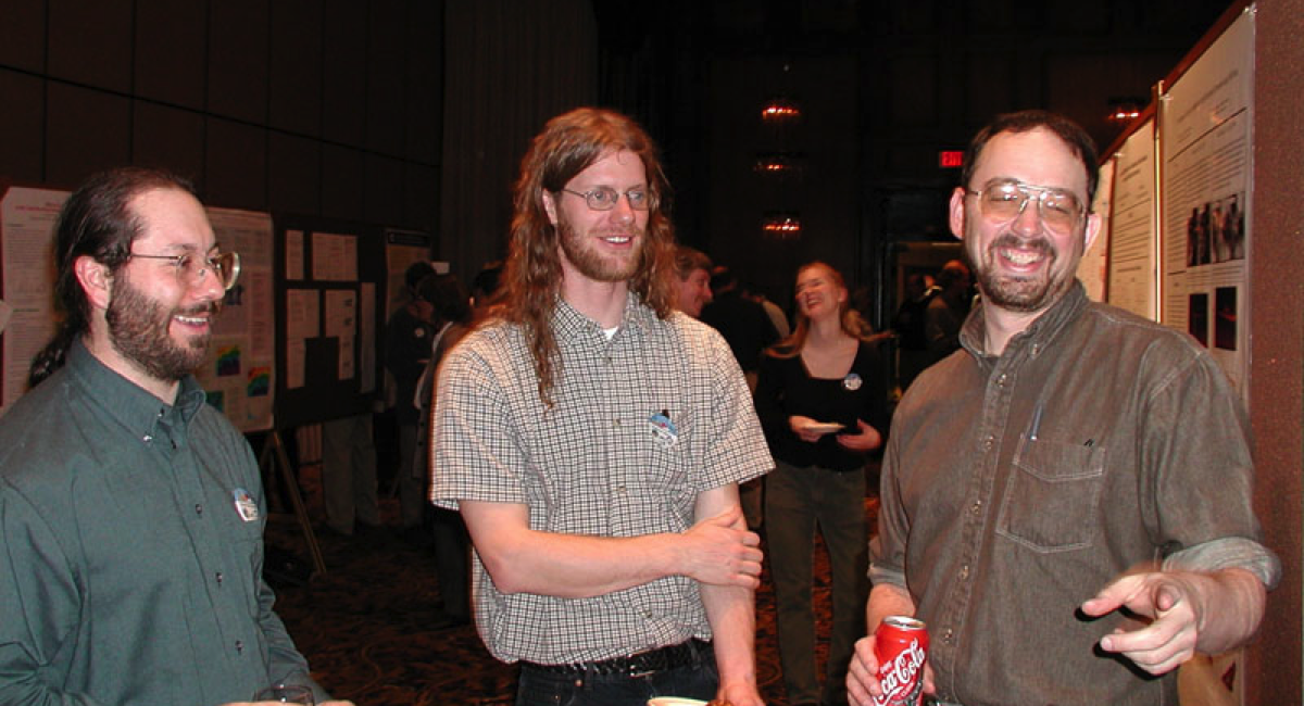 Jay Mace points and smiles at something out of the camera's view while standing with Roger Marchand and Matthew Shupe in the middle. ARM file photo.