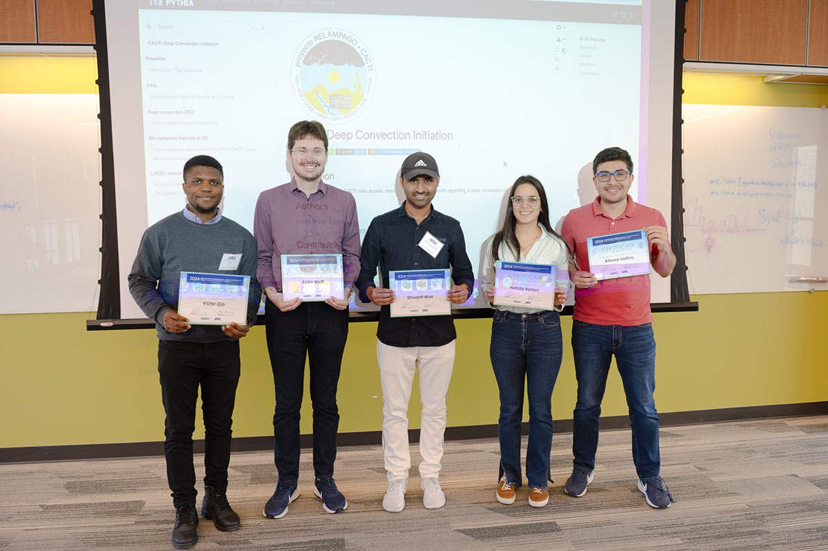 Five people hold certificates while standing in front of a CACTI deep convection Project Pythia cookbook projected onto a giant screen.